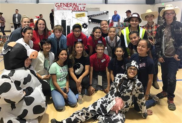 Photo of several junior high students and their adult advisors, some students are wearing cow costumes Photo of several junior high students and their adult advisors, some students are wearing cow costumes